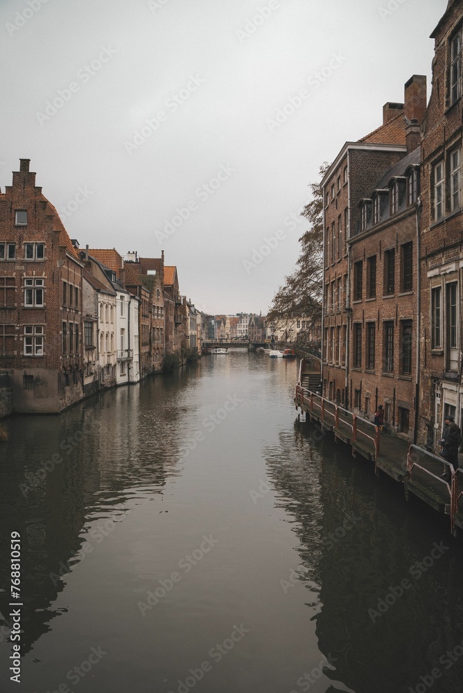 Beautiful view of a canal between old buildings on a foggy day