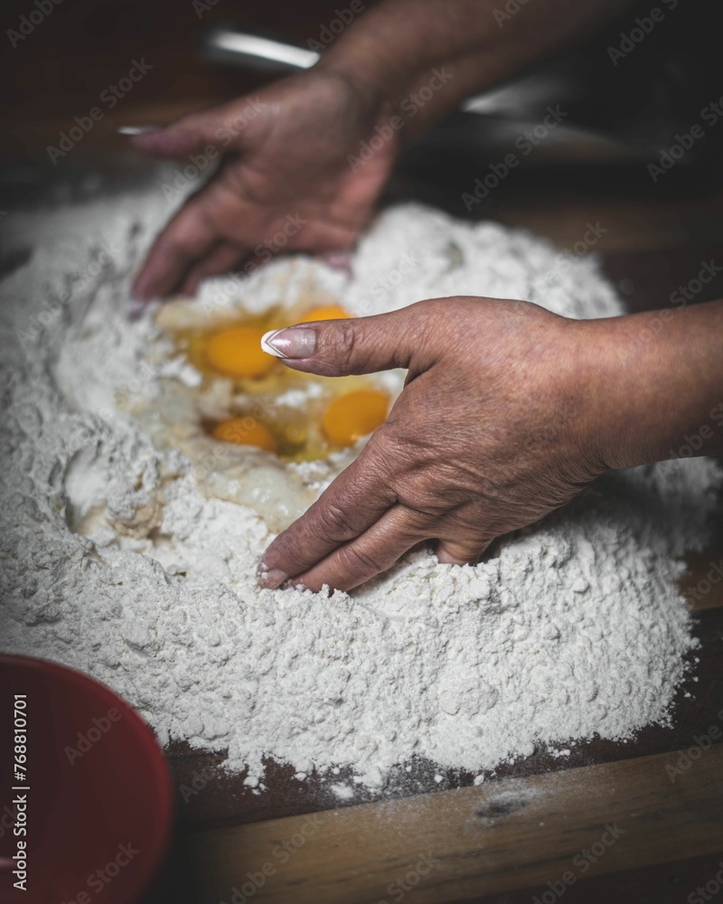 Φωτογραφία Woman kneading eggs in flour for making dough