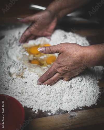 Φωτογραφία Woman kneading eggs in flour for making dough