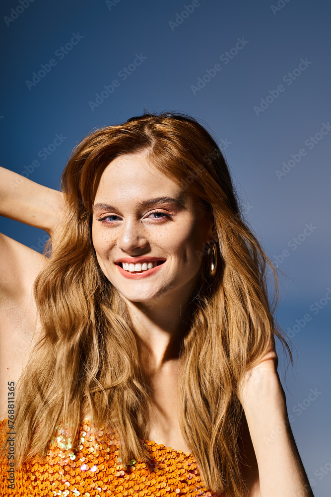 Beauty shot of cheerful young woman smiling, touching her hair on dark blue background Beauty shot of cheerful young woman smiling, touching her hair on dark blue background