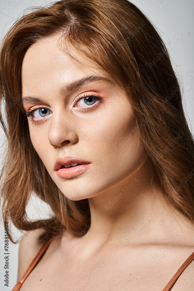 Closeup portrait of attractive girl with peach natural makeup with perfect skin on grey background Closeup portrait of attractive girl with peach natural makeup with perfect skin on grey background