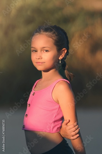 Caucasian teenage girl standing on a beach in sunlight