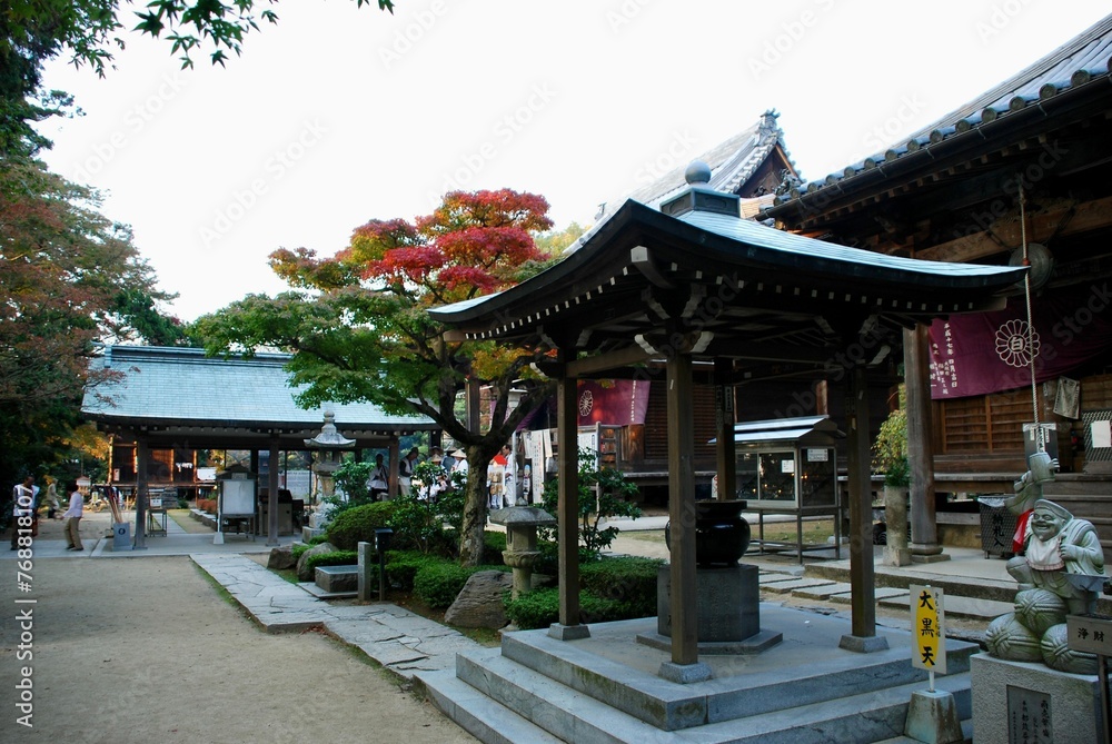 a small pagoda sits next to some shops in a japanese park