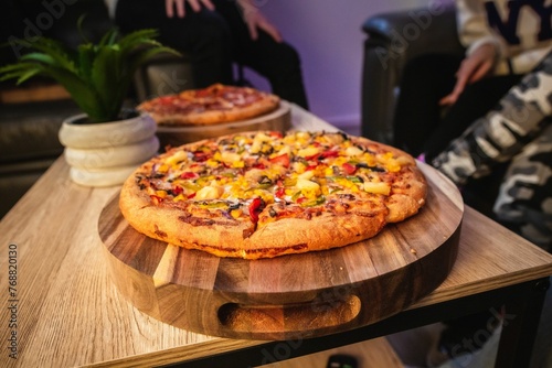 Vegetable topping pizza on a wooden pizza board.