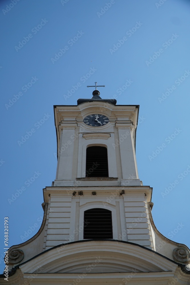 Old church clock in the central town of Visegrad, Hungary, against a blue sky