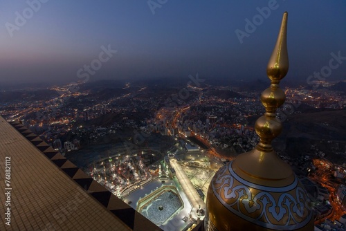 Fotografie Aerial night shot of the Islamic pilgrimage site surrounded by illuminated buildings in Mecca