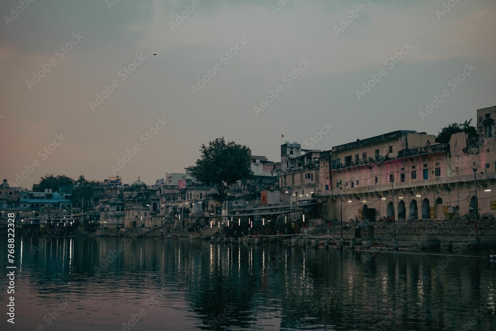 Scenic view of a city with a river running through it, featuring old buildings and houses in India