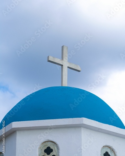 the cross is above the blue dome on the church spire