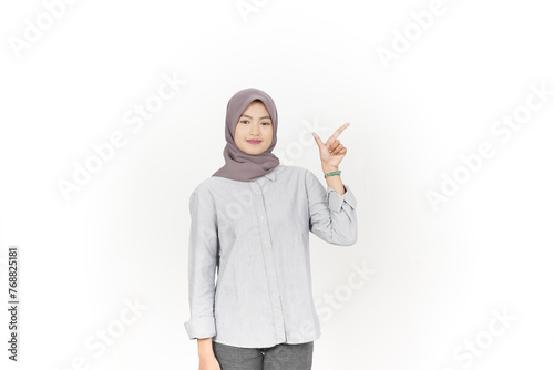 Young Asian woman wearing hijab Pointing side copy space isolated on white background © Sino Images Studio