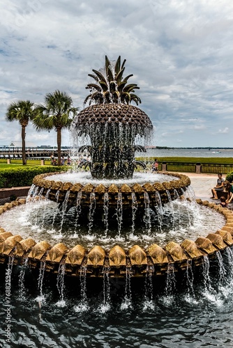 Serene fountain rests in the center of a verdant park, with towering palms encircling the area