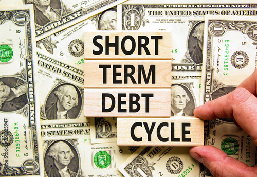 Short term debt cycle symbol. Concept words Short term debt cycle on beautiful wooden block. Beautiful dollar bills background. Dollar bills. Business Short term debt cycle concept. Copy space.