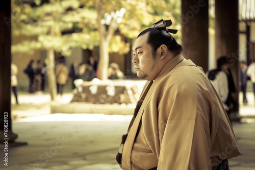 profile of a sumo wrestler in traditional dress, walking toward the dohyo photo