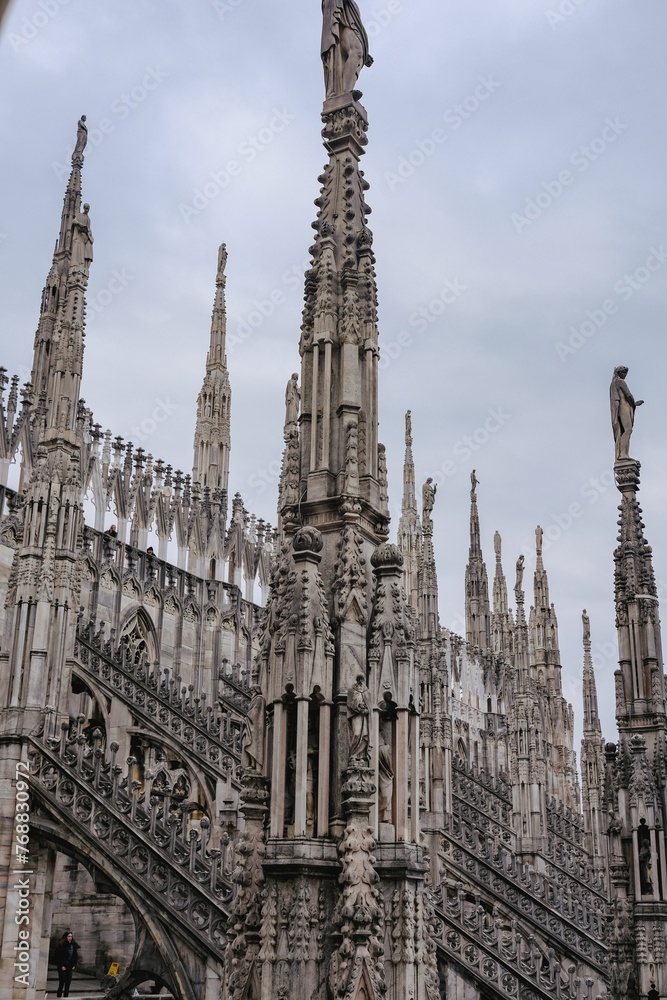 Majestic Duomo di Milano Grand Cathedral with intricate architectural designs against a clouded sky