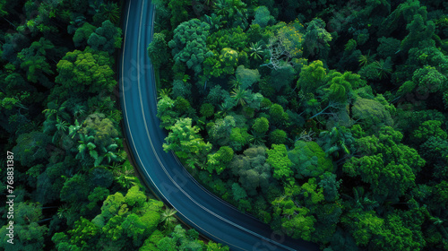 Aerial top view beautiful curve road on green forest in the rain season. © Nhan