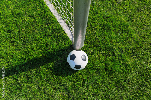 textured soccer game field with ball in front of the soccer goal - soccer ball in soccer net. © Igor