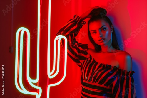 fashion model posing beside a lifesized neon cactus photo