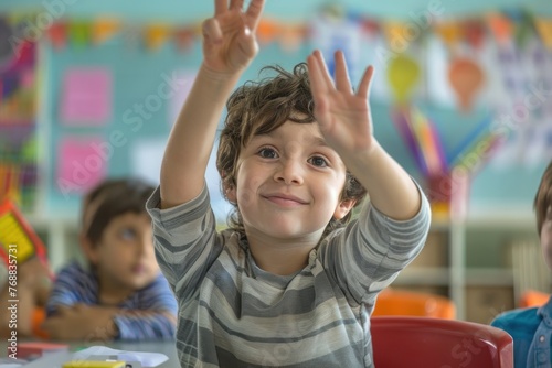 A schoolboy is raising his hand in a school classroom