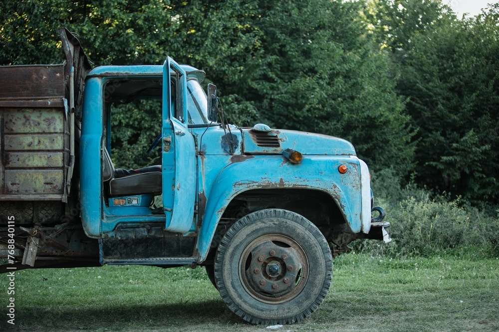 Vintage weathered old blue truck on a grassy field
