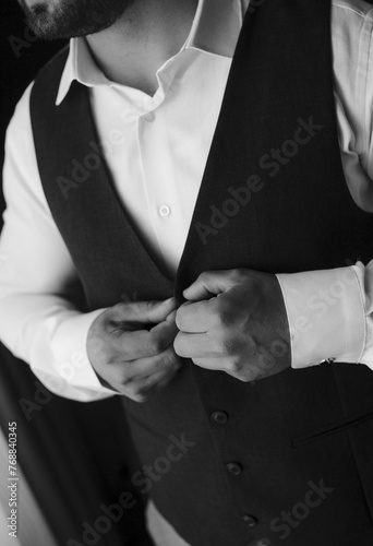 Vertical of a groom hearing classic suit in grayscale