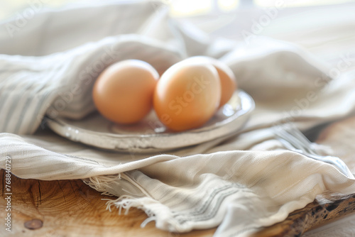 Fresh farm eggs on a plate, linen cloth over a rustic wooden table. Farm and natural produce concept. Design for cookbook recipes, food blog headers with copy space, and organic product packaging. photo