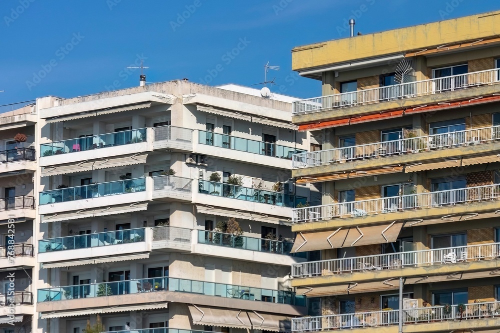Obraz premium Scenic view of two residential buildings next to each other under a blue sky.