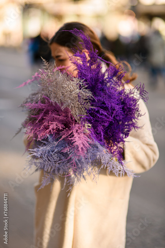 Young woman holds a bunch of pink, white and purple asparagus in her hands