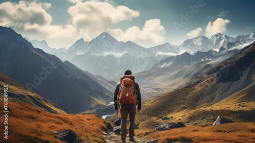 A man is hiking in the mountains with a backpack. The mountains are covered in snow and the sky is cloudy. The man is looking out over the landscape, taking in the beauty of the mountains