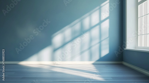 Sunlit empty room with bluish tint, casting shadows on walls and floor, modern minimalistic product showcase, ideal for minimalist design background