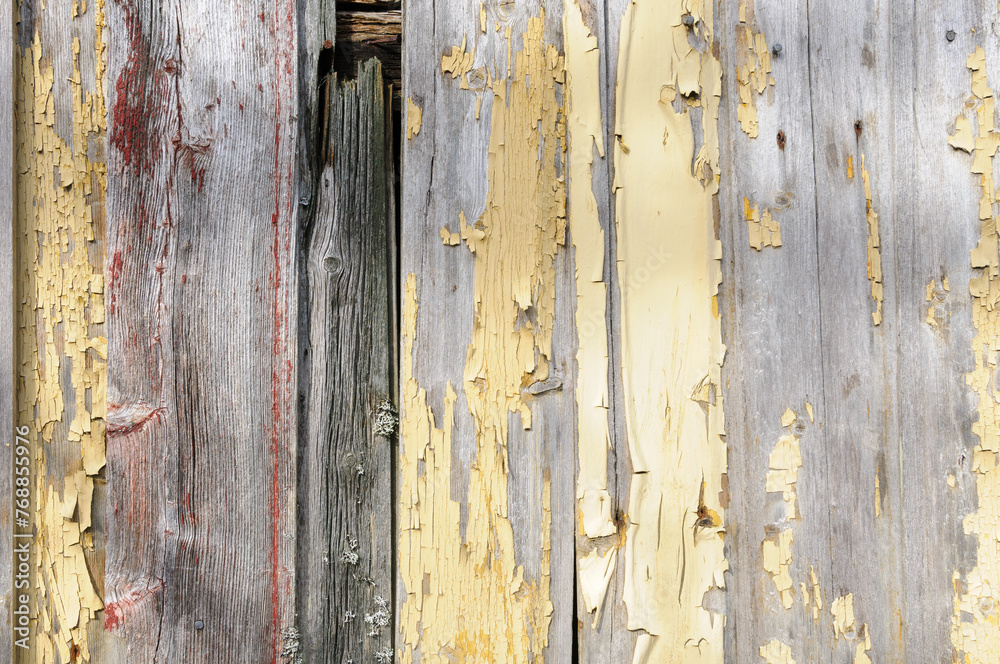 Close-up of aged wooden planks with flaking yellow paint, revealing layers of history. Close-up of aged wooden planks with flaking yellow paint, revealing layers of history.