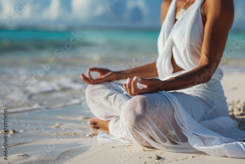 Close up of a woman sitting on the beach mediating photo