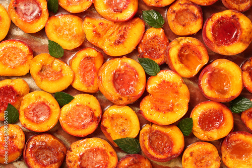 Top down view of healthy and delicious fruity dessert with half sliced peaches, baked with honey, cinnamon, butter and fresh mint leaves.