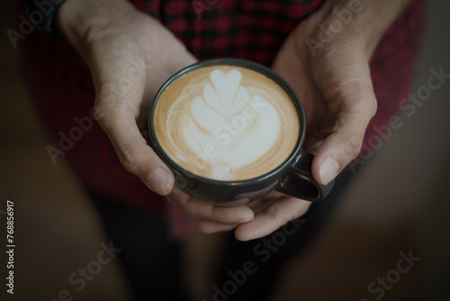 Hand people holding the coffee cup and the joy of enjoying a homemade latte coffee. Clos up