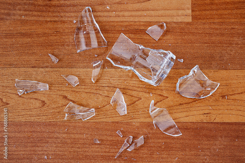 Broken or shattered drinking glass on wood floor