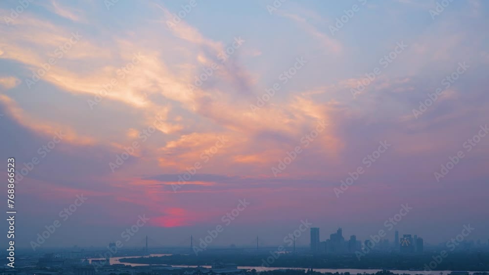 Time lapse interval sunset over modern office buildings in business district. Skyline cirrus cloudscape view of cityscape with disc sun sunlight and flare. Time lapse interval sunset over modern office buildings in business district. Skyline cirrus cloudscape view of cityscape with disc sun sunlight and flare.