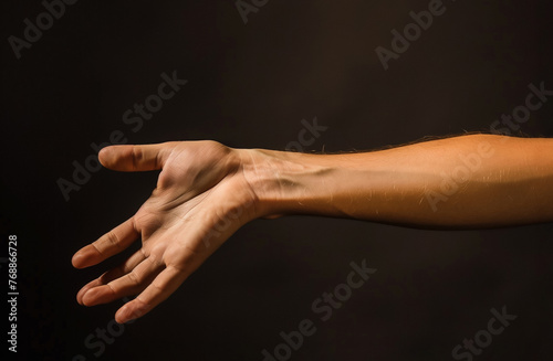 Open human right hand showing the wrist and forearm isolated on black background. A man's arm palm up with copyspace