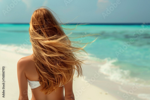 Wallpaper Mural Young woman with long windy hair enjoying the breeze at beach. Beautiful girl relaxing at beach during summer holiday, back view Torontodigital.ca