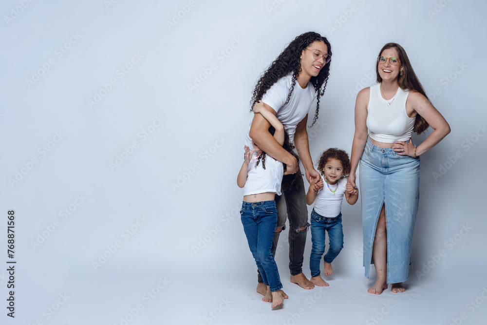 young latin family of father mother and two daughters, having fun posing and smiling, studio shot young latin family of father mother and two daughters, having fun posing and smiling, studio shot