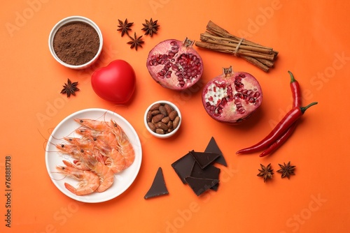 Natural aphrodisiac. Different products and heart model on orange background, flat lay