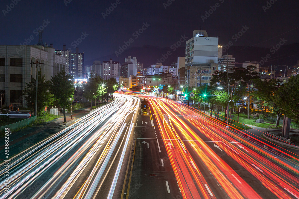 The night view of the city with the trajectory of car lights of various colors expressed by long exposure.