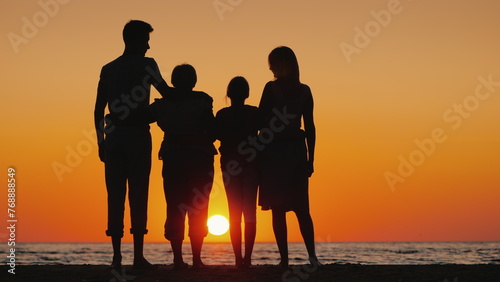 Happy multi-generational family enjoying sunset over the sea