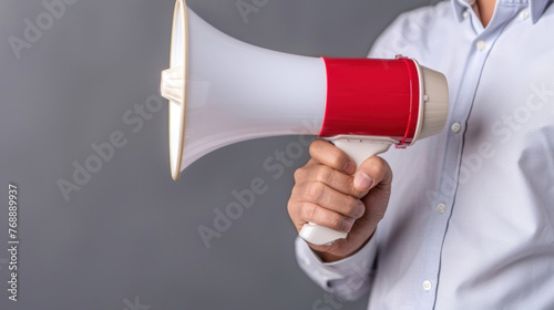 A man holding a red and white megaphone, preparing to speak through the device