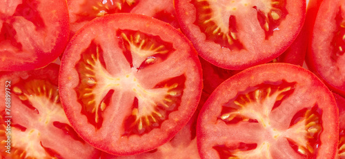 Cut red organic tomatoes close-up. Juicy red food background. © Baurzhan I