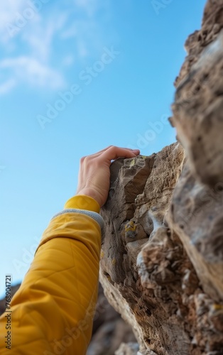 Close up of climber hand holding a tiny edge on the rock