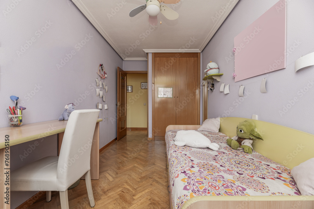 Fototapeta premium A bedroom with a youth bed with a wooden headboard, an attractive duvet cover and a built-in wardrobe with oak doors