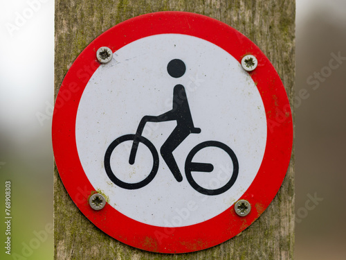 A ROUND PROHIBITION SIGN FOR CYCLING IN RED AND WHITE