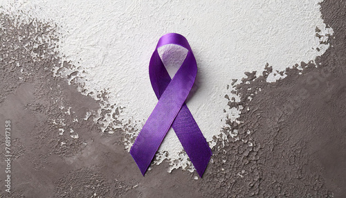 Purple satin awareness ribbon isolated on putty background. Animal abuse, Alzheimer's disease, domestic violence photo