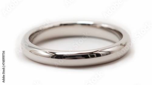 Close up of a perfectly polished silver ring with a soft shadow and reflection on a plain white background