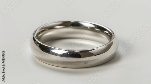 High-quality image of a silver wedding band with a highly reflective surface on a grey gradient background