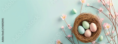 Easter holiday celebration banner greeting card with pastel painted eggs in bird nest on bright blue backround tabel texture. Top view, flat lay with copy space  photo