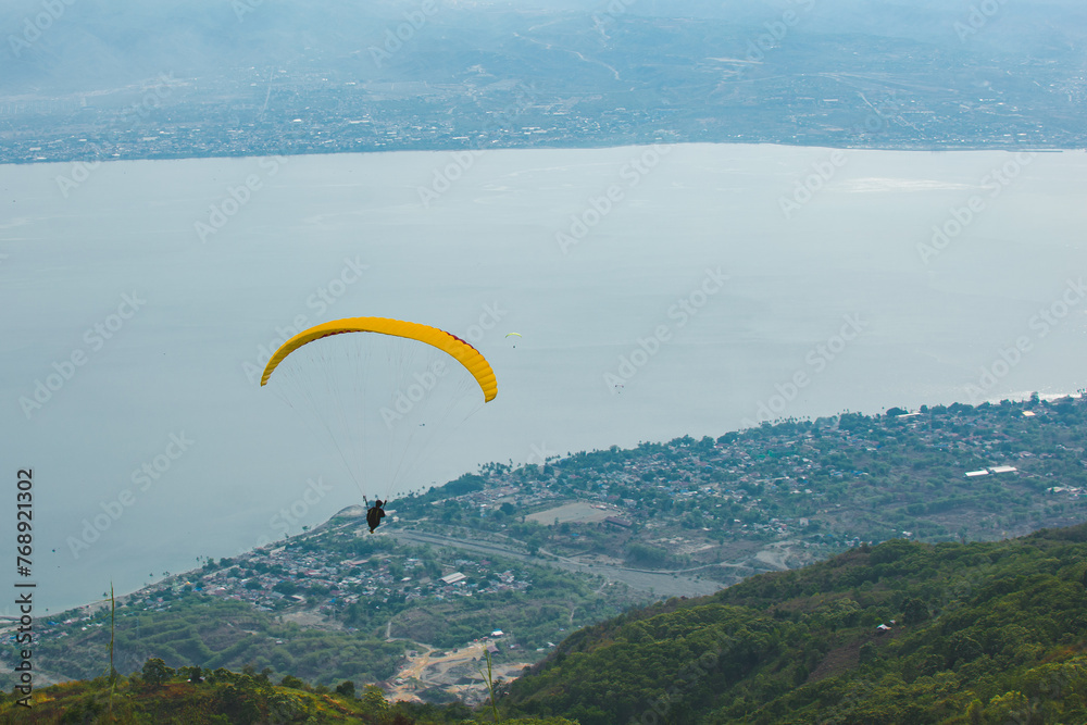 Paragliding soars at salena peak, palu city, Central sulawesi. Paragliding soars at salena peak, palu city, Central sulawesi.